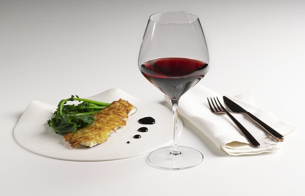 Filetto di branzino in crosta di patate, riduzione di vino rosso e cime di rapa