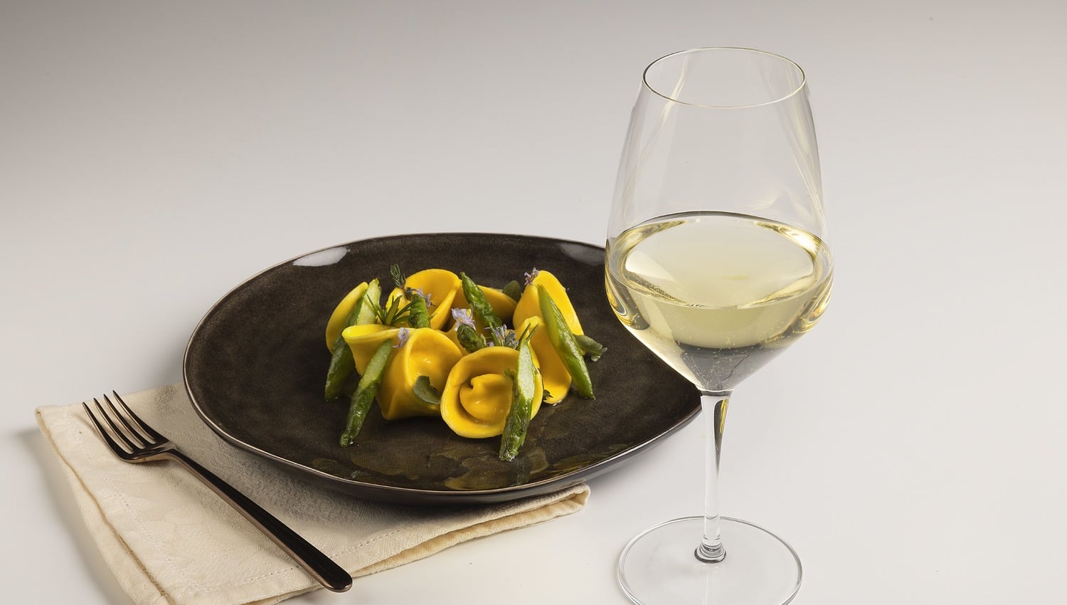 Tortelli con robiola e arancia, burro alle erbe e asparagi