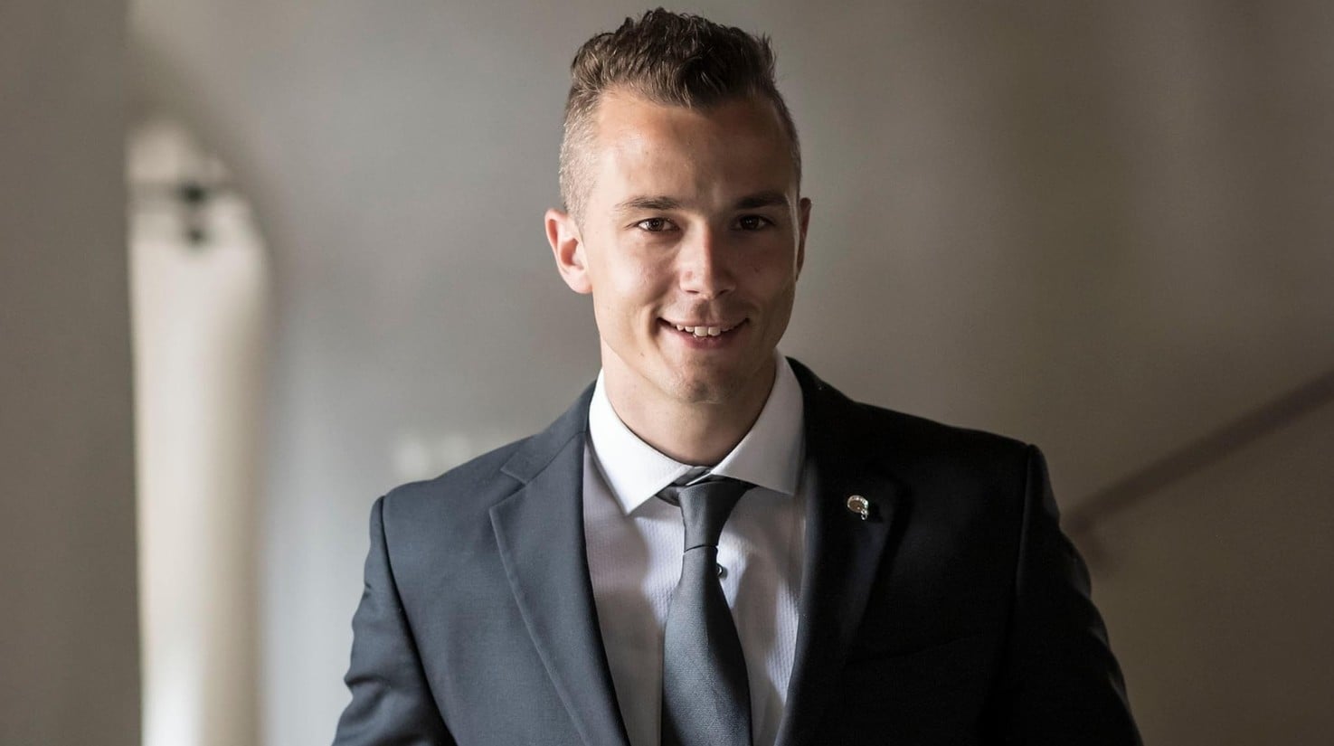 Ritratto di Bastian Winkler, raffigurato sorridente in un abito elegante.